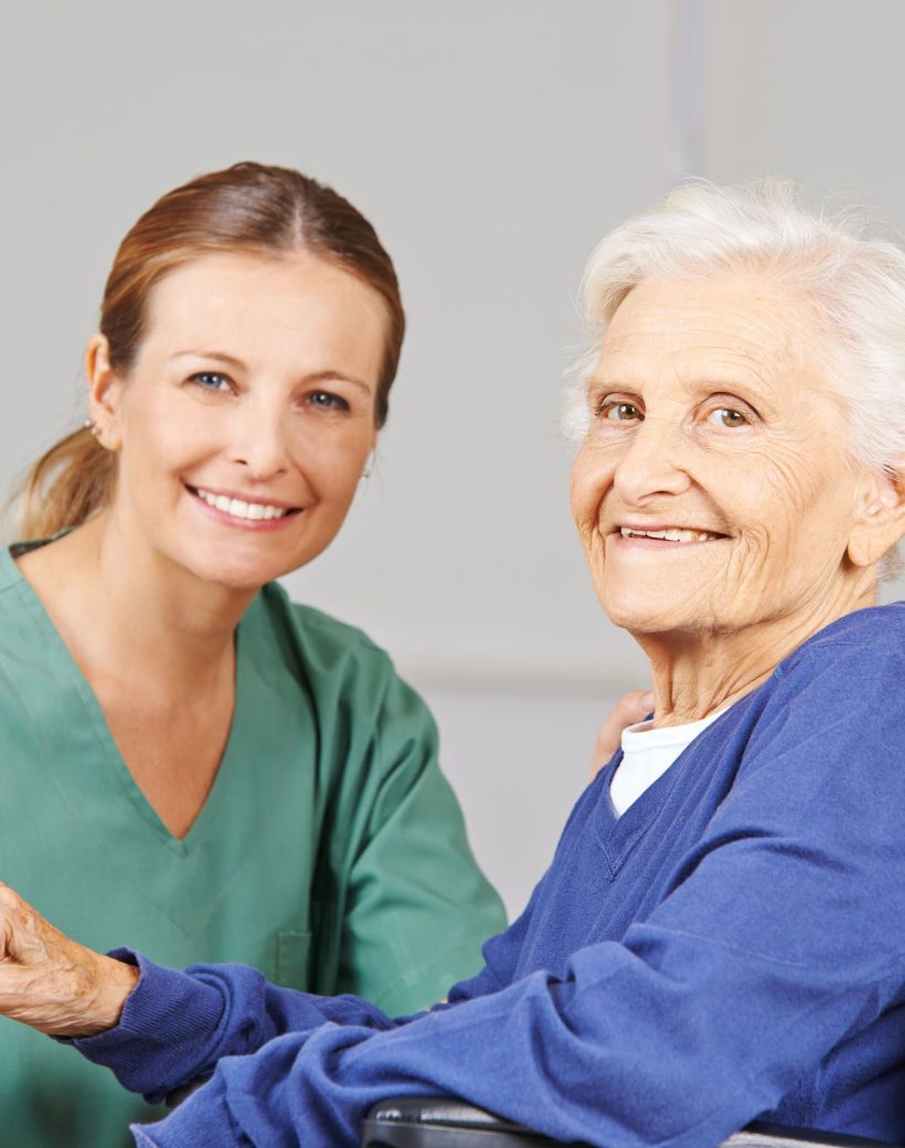 Geriatric care with nurse and happy senior woman in a wheelchair